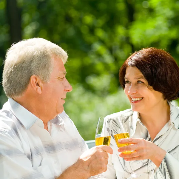 Äldre par firar med champagne, utomhus — Stockfoto
