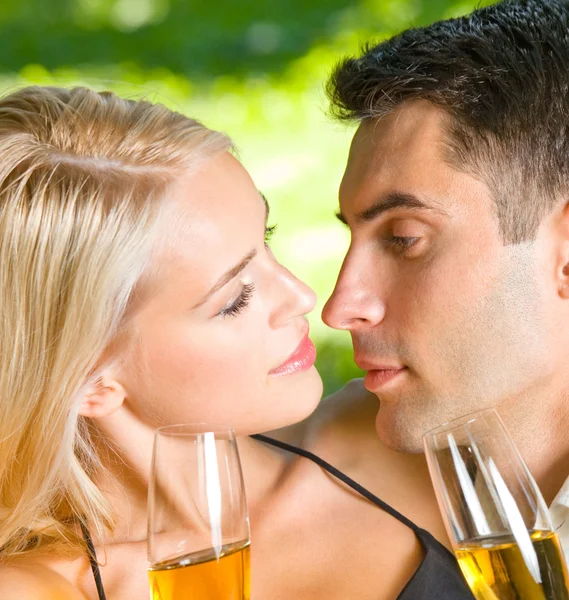 Молодая счастливая пара с шампанским, на открытом воздухе — стоковое фото
