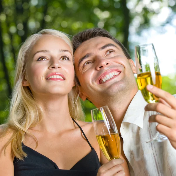 Jovem casal feliz com champanhe, ao ar livre — Fotografia de Stock
