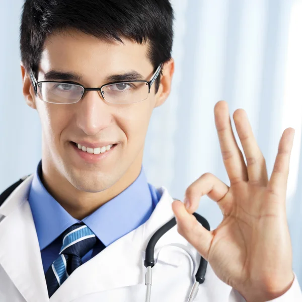 Leende läkare med okej gest, på kontor — Stockfoto