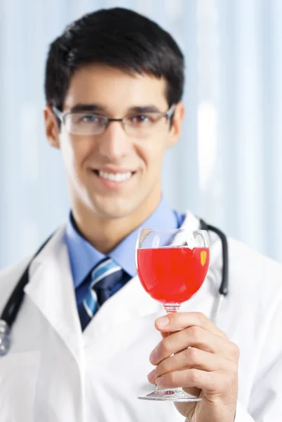 Jeune médecin souriant avec vin rouge — Photo