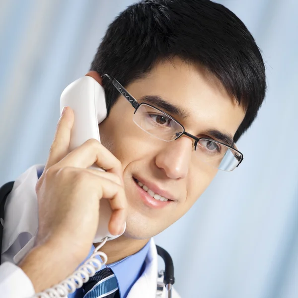 Młody lekarz na telefon, w urzędzie — Zdjęcie stockowe