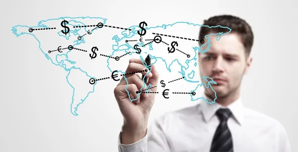 Junger Geschäftsmann zeichnet ein globales Netzwerk mit Dollarzeichen auf der Weltkarte. — Stockfoto