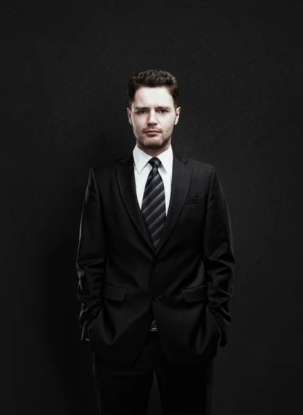 Portrait of a young businessman standing with his hands in the pockets — Stock Photo, Image