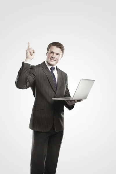 Gelukkig jonge zakenman met laptop duimen opdagen. — Stockfoto