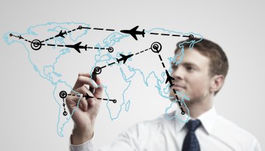 Young business man drawing an airplane routes on world map clipart