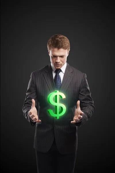 Giovane uomo d'affari sceglie un segno verde dollaro USA — Foto Stock