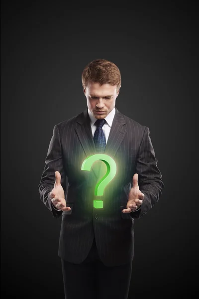 Young businessman with a question mark on his hands — Stock Photo, Image