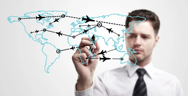 Young business man drawing an airplane routes on world map. — Stock Photo, Image