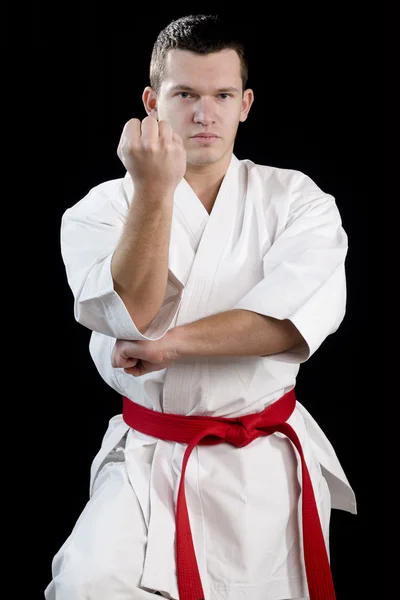 Contrast karate young fighter on black — Stock Photo, Image
