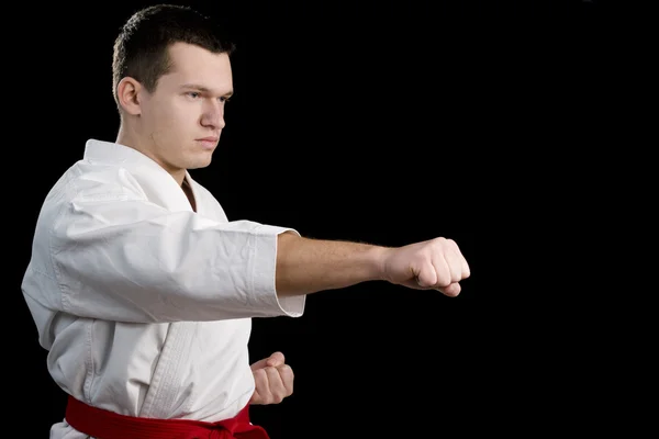 Contrast karate young fighter on black — Stock Photo, Image