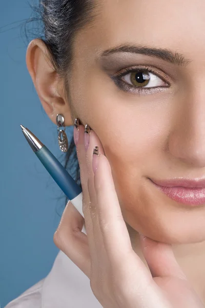 Boldog, fiatal nő, egy tollal a kezében, mint kék háttér — Stock Fotó