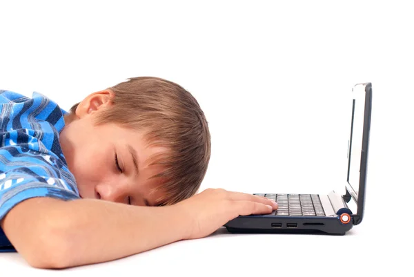 Niño durmiendo en el suelo cerca de la computadora portátil — Foto de Stock