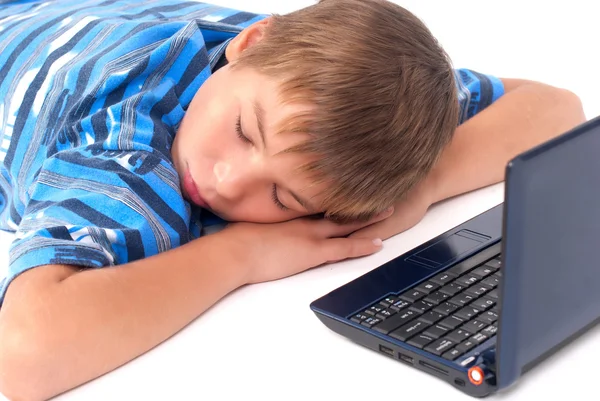 Niño durmiendo en el suelo cerca de la computadora portátil — Foto de Stock