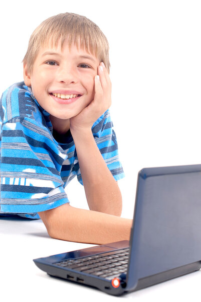 Smiling young boy in front of laptop.