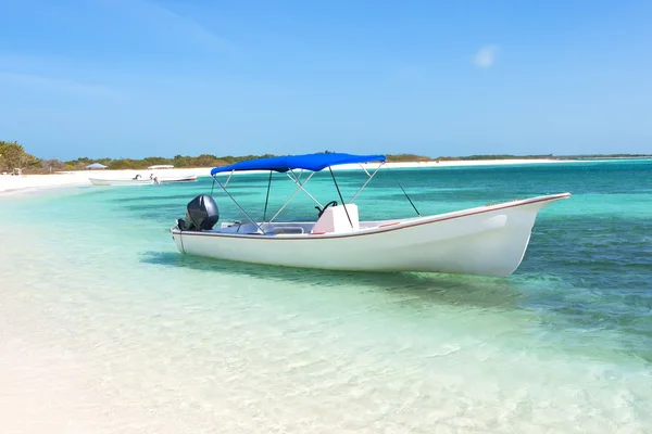 Лодка на тропическом пляже — стоковое фото