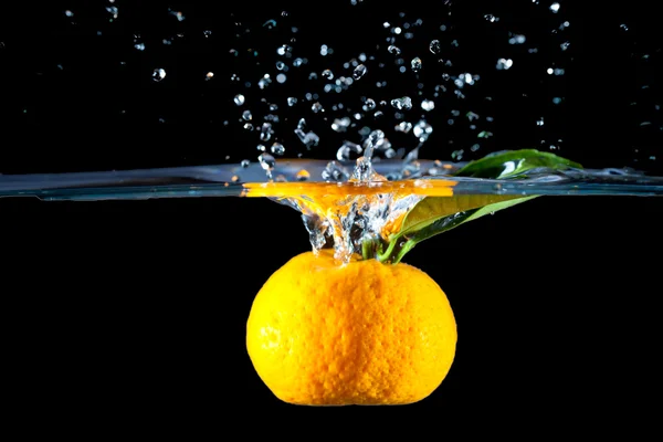 Апельсин упал в воду — стоковое фото