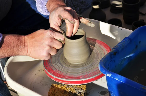 Řemeslník vytváří hliněný hrnec s soustruh — Stock fotografie