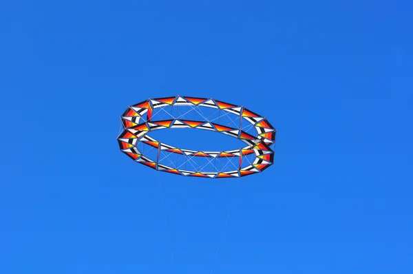 Circular kite flying in a blue sky — Stock Photo, Image