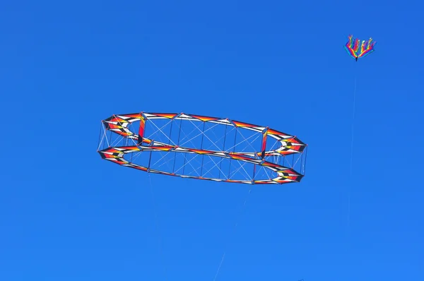 Круговой воздушный змей, летящий в голубом небе — стоковое фото