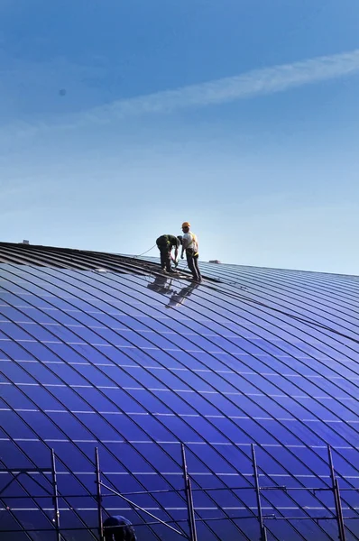 Instalación de paneles solares en el techo de un edificio Fotos de stock libres de derechos