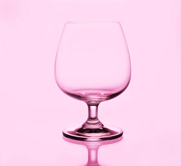 Brandy sklenice na růžovém pozadí — Stock fotografie