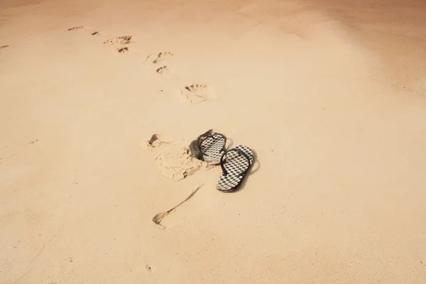 Шлепанцы на песке — стоковое фото