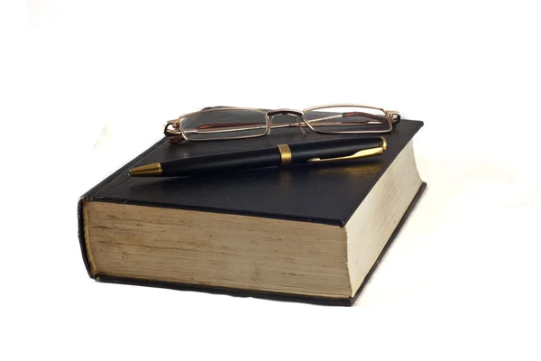 Pen and glasses on a book — Stock Photo, Image