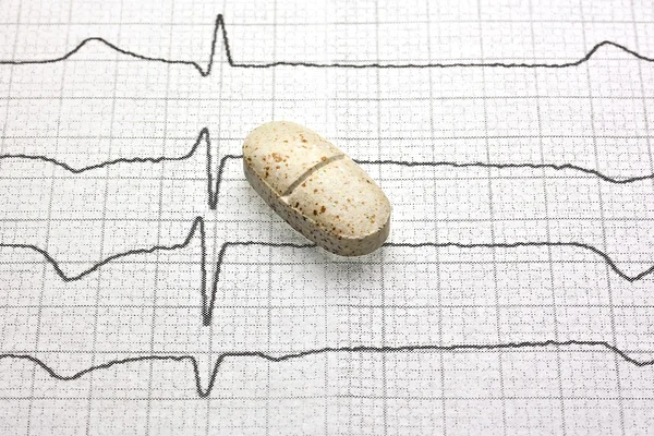 Tablet op cardiogram — Stockfoto