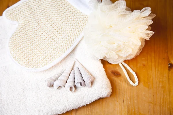 Luxus-Badewanne oder Duschset mit Handtuch, Handschuh und Muscheln auf Holzgrund — Stockfoto