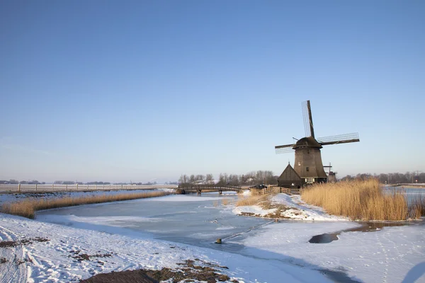 Windmühle im Winter mit Schnee und blauem Himmel — Stockfoto
