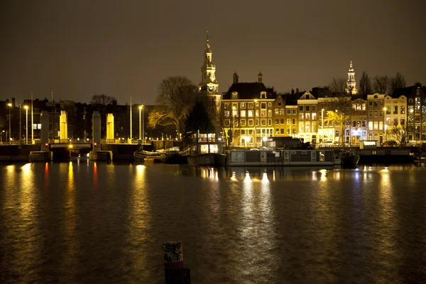View at Amsterdam at night with canal and historic buildings — Stock Photo, Image