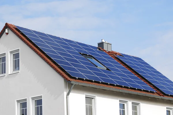 Modernes Hausdach mit Sonnenkollektoren lizenzfreie Stockbilder