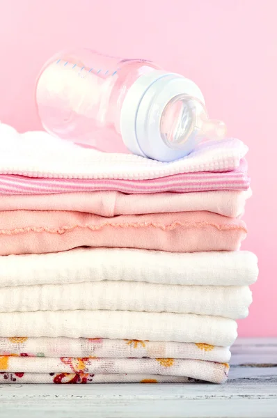 Garrafa de bebê e roupas rosa — Fotografia de Stock