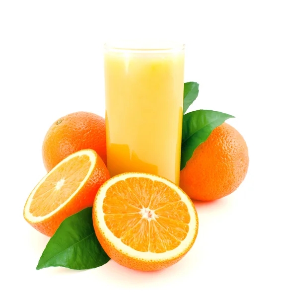 stock image Ripe oranges with green leaves and juice glass.