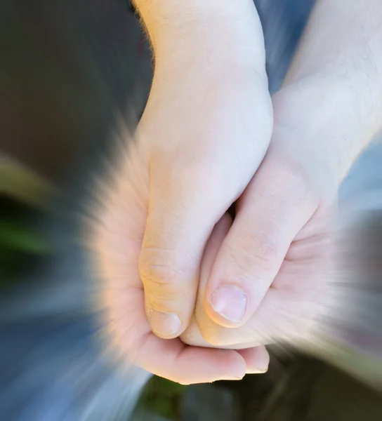 Дитячі руки тримають промені сяючого світла — стокове фото
