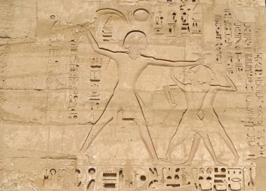 Egyptian hieroglyphic carvings on a wall clipart