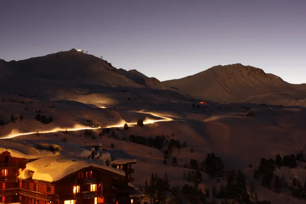 Atardecer sobre una aldea alpina nevada — Foto de Stock