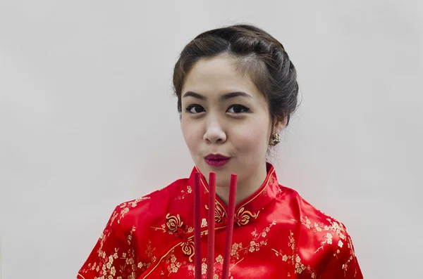 Jovem chinesa com roupas de tradição segurando paus joss ( — Fotografia de Stock