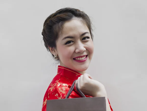 Vacker kvinna i röd traditionella kinesiska cheongsam, shopping väska — Stockfoto