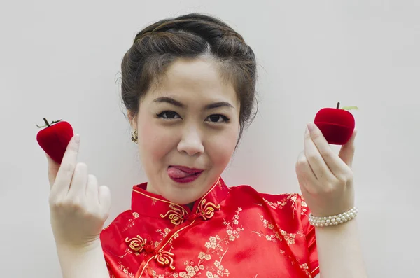 Hymyilevä kaunis kiinalainen nainen, jolla on mansikka ja omena — kuvapankkivalokuva