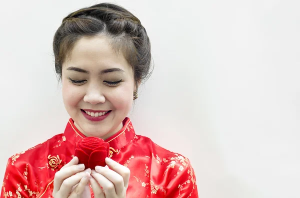 Χαμογελώντας όμορφη Κινέζα, κοιτάζοντας το τριαντάφυλλο — Φωτογραφία Αρχείου