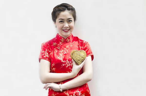 Beautiful asian woman wear cheongsam and holding golden heart — Stock Photo, Image