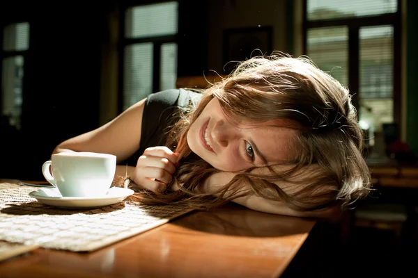 Chica en un café con una taza de café — Foto de Stock
