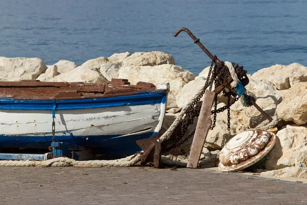 Старая деревянная лодка и ржавый якорь — стоковое фото