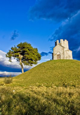 Idyllic chapel on the green hill clipart