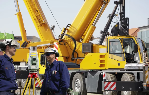 Building workers and mobile cranes — Stock Photo, Image