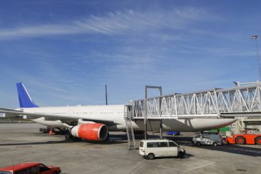 Airplane parked at passenger terminal clipart