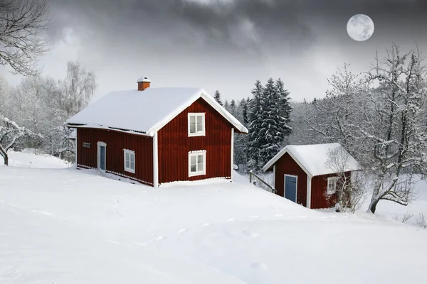 Červené domky v lese sněhu za úplňku — Stock fotografie