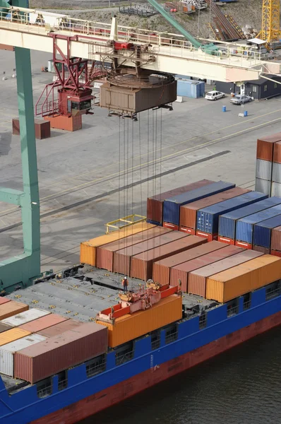 Кран опускает контейнеры на корабль — стоковое фото